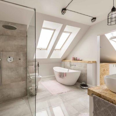 Modern bathroom interior with minimalistic shower and lighting, white toilet, sink, bathtub and roofwindows
